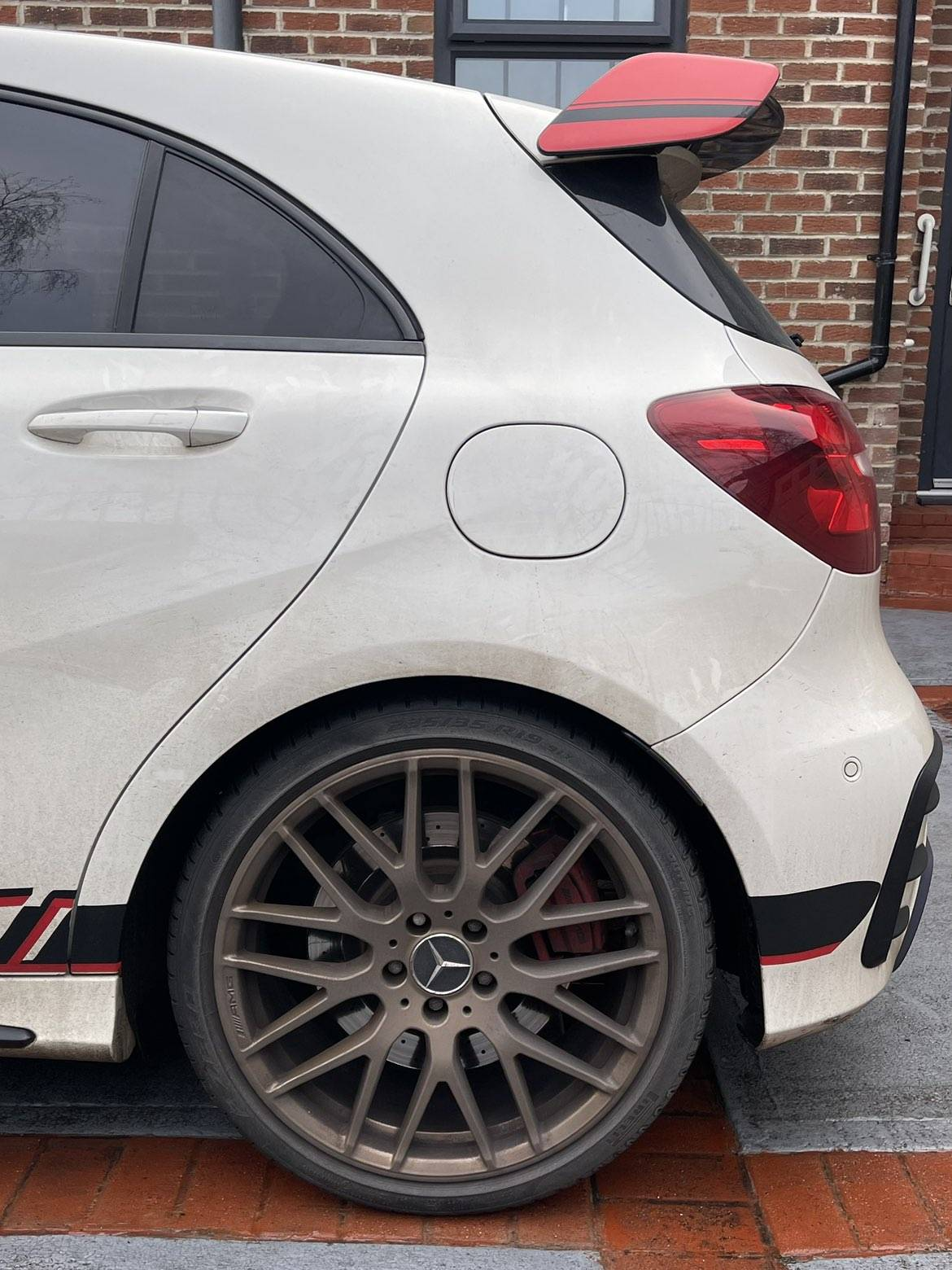 Rear wheel and bodywork of white Mercedes before detailing